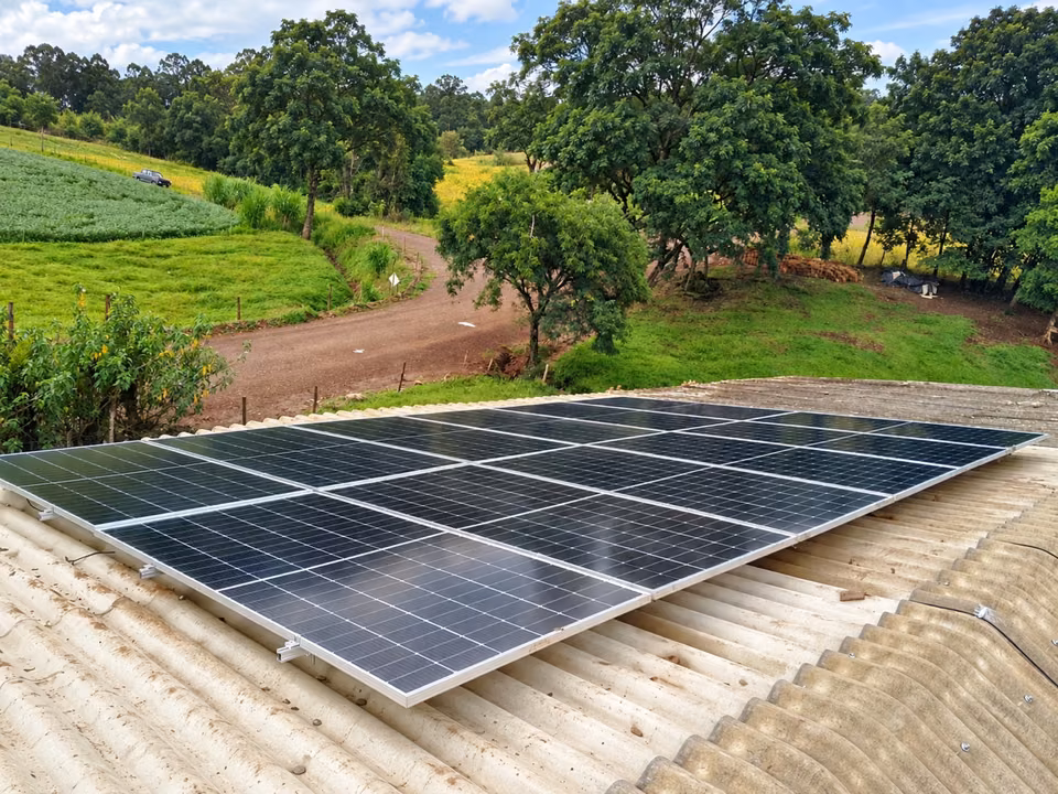 Painéis solares sobre telhado ao lado de uma área verde, em Bom Jesus do Oeste.